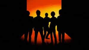 Silhouetted five-member rock band standing shoulder-to-shoulder in front of a glowing orange rectangular backdrop, their dark figures and floor reflections creating a bold, promotional-style portrait.