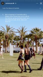 SoHo House Instagram story promoting "The Hideout at Coachella" with white text over a clear blue sky and a grassy festival lawn lined with palm trees. In the foreground two women in festival outfits and boots walk across the grass carrying black tote bags while other attendees mill about.